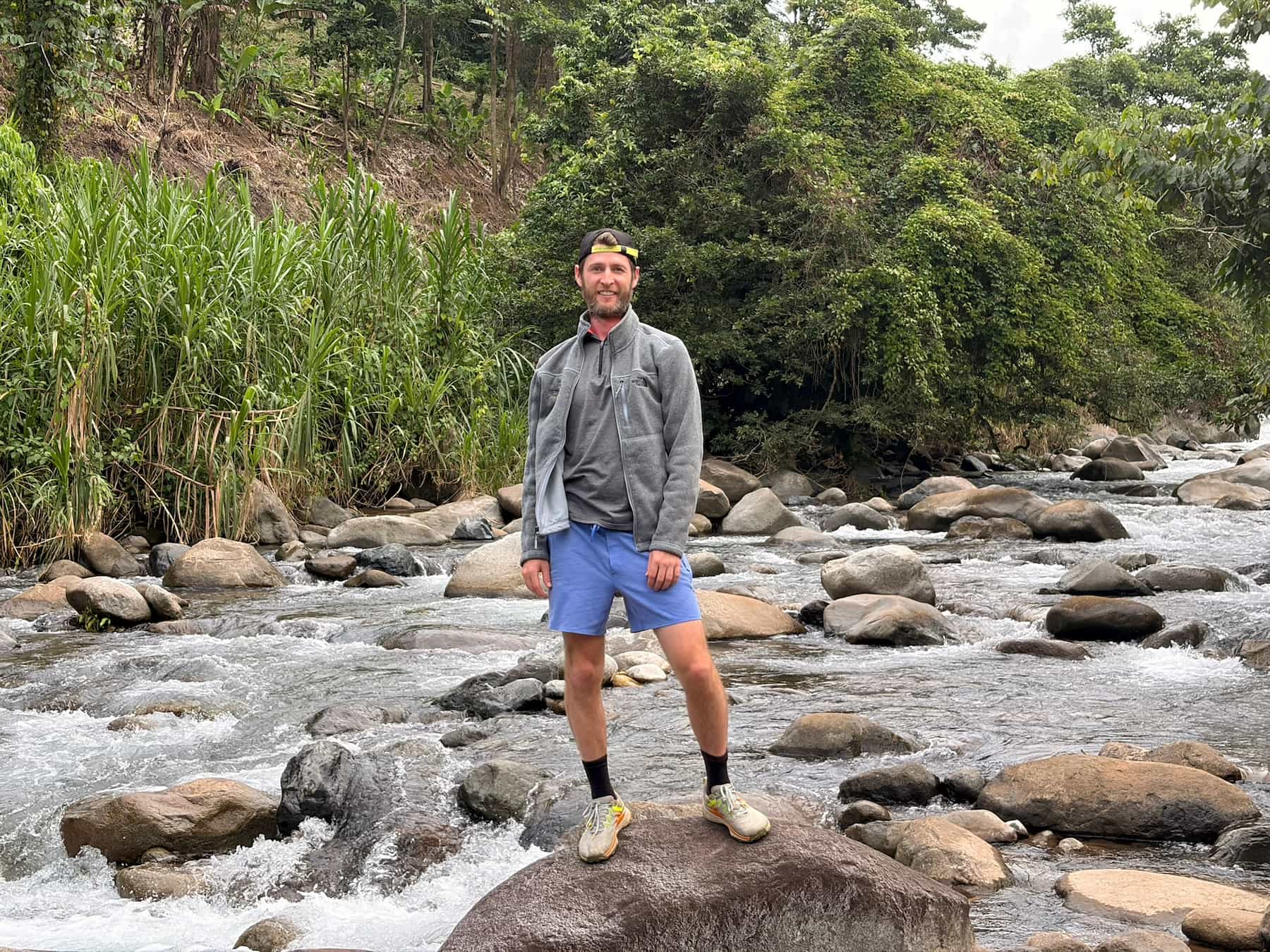 Reid standing on rocks beside the river during his immersion.