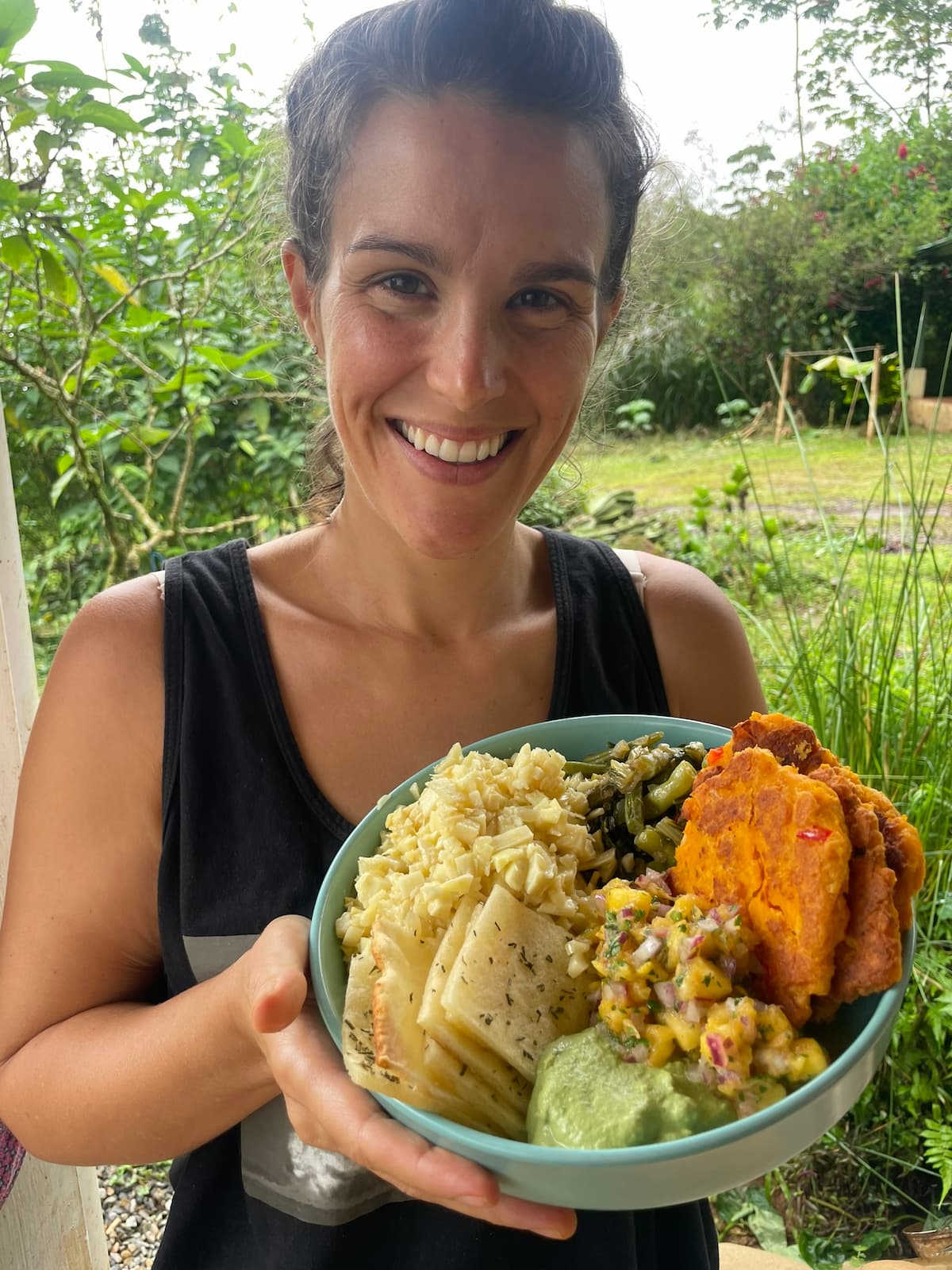 Yara holding a bowl of food she prepared at the homestead